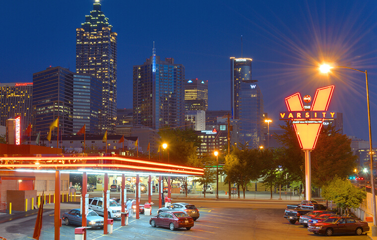 Varsity sign against Atlanta skyline at night